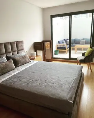 a bedroom with a large bed and a piano at Appartement haut standing au quartier les princesses avec grande terrasse et parking gratuit in Casablanca