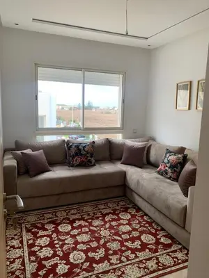 a living room with a couch and a window at Appartement à louer dans une résidence balnéaire 3 piscines - RAMOFLORES Sidi Rahal in Sidi Rahal