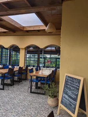 a restaurant with wooden tables and chairs and a chalkboard at Mesdunes in Azemmour