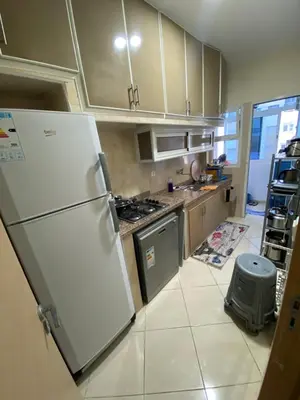 a kitchen with a white refrigerator and a stove at Échappez à la ville , Appartement près de la nature, entre forêt et plage juste pour les familles in Skhirat
