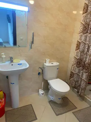 a bathroom with a toilet and a sink at Magnifique Appartement avec Piscine à Tamaris in Tamaris
