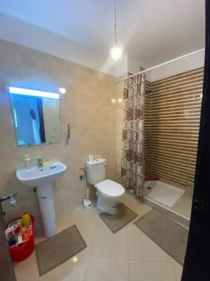 a bathroom with a toilet and a sink and a shower at Magnifique Appartement avec Piscine à Tamaris in Tamaris