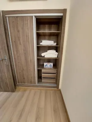 a closet with wooden doors in a room at Central Park House - 70m² in Mohammedia