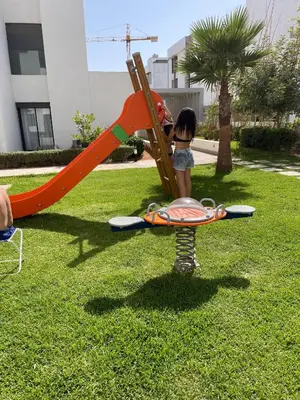 a little girl is playing on a playground at Joli appartement à Harhoura in Oulad Kerroum