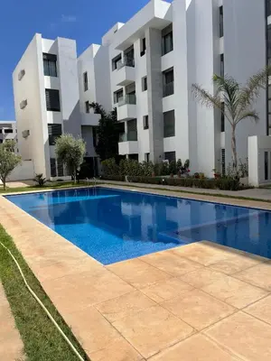a swimming pool in front of a building at Joli appartement à Harhoura in Oulad Kerroum