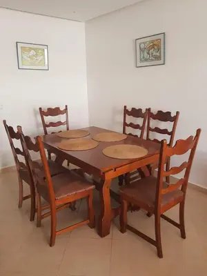 a wooden table with four wooden chairs around it at Beach-Side 2-BR Oasis with Private Pool & Parking in Casablanca