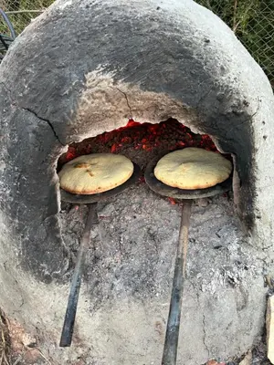 three pizzas are cooking in a stone oven at American Farm Villa Grand Casablanca/El Jadida in Zaouia Sidi Bou Azza