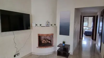 a living room with a fireplace with a flat screen tv at My Cosy Place Rabat - Skhirat 2min de la plage avec Piscine in Skhirat
