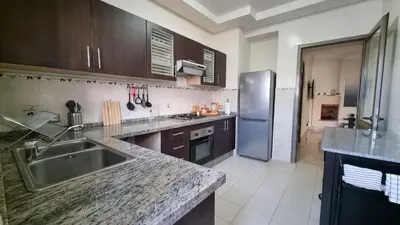 a kitchen with a sink and a stainless steel refrigerator at My Cosy Place Rabat - Skhirat 2min de la plage avec Piscine in Skhirat