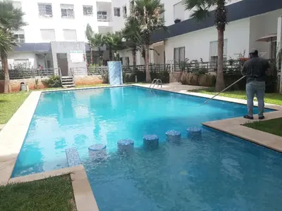 a man with a hose in a swimming pool at Belfakih in Beni Brour