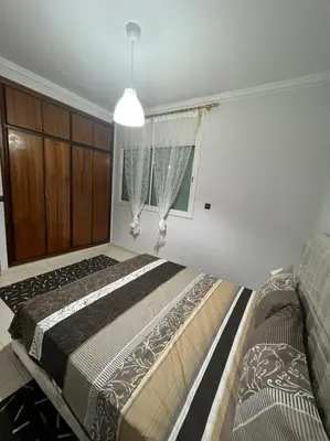 a bedroom with a large bed and a window at Magnifique appartement proche Arribat Center in Rabat