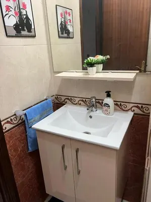 a bathroom with a white sink and a mirror at Magnifique appartement proche Arribat Center in Rabat