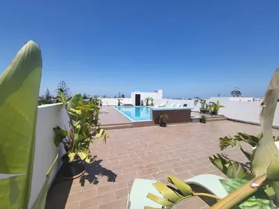 a view of a patio with plants and a swimming pool at Les Jardins de l'Oasis - 2 rooms in Casablanca