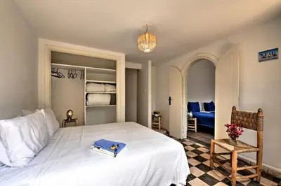 a bedroom with a bed with a book on it at Charmante Maison 2ch et Bungalow 2ch au Coeur de l'Oasis in Casablanca
