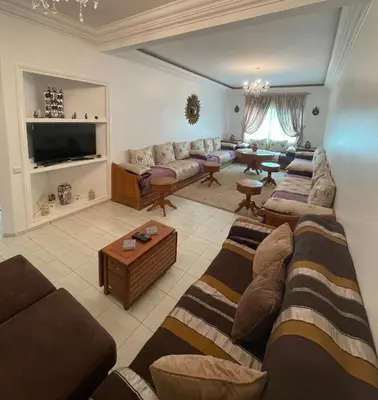a large living room with couches and a tv at Appartement standing spacieux Casablanca in Casablanca
