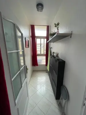 a hallway with a black cabinet and a window at Appartement standing spacieux Casablanca in Casablanca
