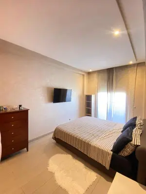 a bedroom with a bed and a tv on the wall at Bright and Comfortable Stay by Stade Mohammed V in Casablanca