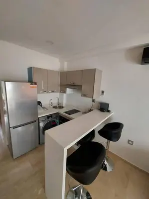 a kitchen with a counter and two bar stools at Havre de paix au cœur de Casa in Casablanca