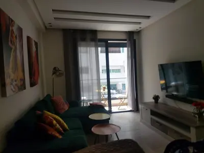 a living room with a green couch and a television at Havre de paix au cœur de Casa in Casablanca