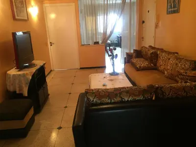 a living room with a couch and a tv at Property located in a quiet area close to the train station and town in Casablanca