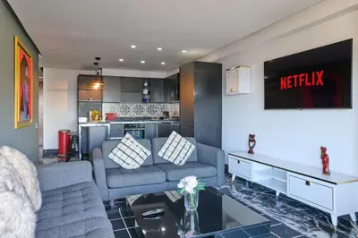 a living room with a couch and a kitchen at TheCasaEdition - Bel Azur - Sea View & Hassan II Mosqué Residency in Casablanca
