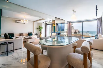a living room with a glass table and chairs at TheCasaEdition - Bel Azur - Sea View & Hassan II Mosqué Residency in Casablanca