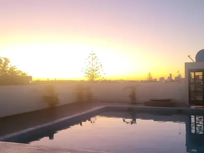 a swimming pool with the sunset in the background at Chez Bebel in Casablanca