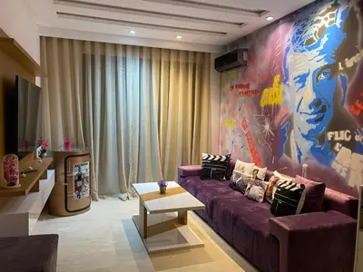 a living room with a purple couch and a large mural at Chez Bebel in Casablanca