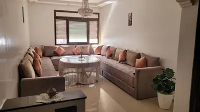 a living room with a couch and a table at Bel Appartement spacieux 3 pièces avec double salon Paisible & Proche de la Gare d'Agdal in Rabat
