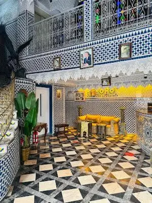 a living room with yellow chairs and a checkered floor at HOTEL AL MAMOUN in Casablanca