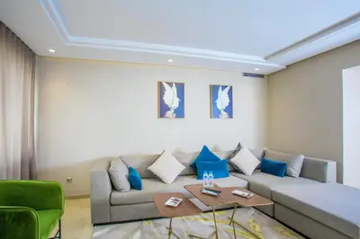 a living room with a couch and blue pillows at Top flat at central Massira Maarif in Casablanca