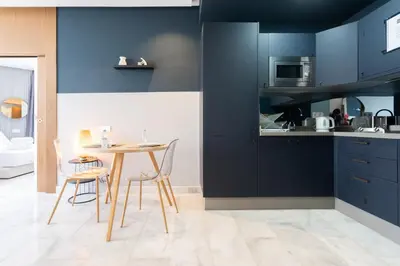 a kitchen with blue cabinets and a table and chairs at c4 .super appartement with parking in Casablanca