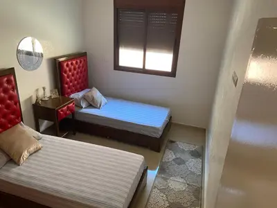 a small room with two beds and a window at Apparemment à mohammadia in Mohammedia