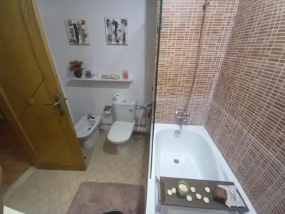 a bathroom with a toilet and a bath tub at Appartement la perle de Nouaceur in Nouaceur