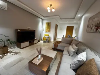 a living room with a couch and a tv at Ocean Palm Aρραrt Pοοl Vieω in Casablanca