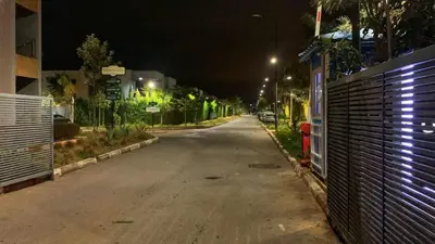 an empty street at night with a fence and buildings at Ocean Palm Aρραrt Pοοl Vieω in Casablanca