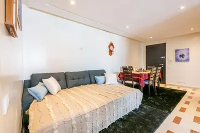a bedroom with a large bed and a table at Layover Guest House Apartment & parking Rabat Agdal City Center in Rabat