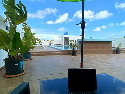 a laptop sitting on a table with an umbrella at Superbe Appartement avec piscine et jacuzzi privé in Casablanca