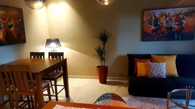 a living room with a blue couch and a table at Superbe Appartement avec piscine et jacuzzi privé in Casablanca