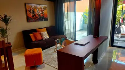 a living room with a table and a couch at Superbe Appartement avec piscine et jacuzzi privé in Casablanca