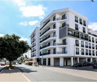 a white building with cars parked in front of it at Upscale flat with Gym in Casablanca