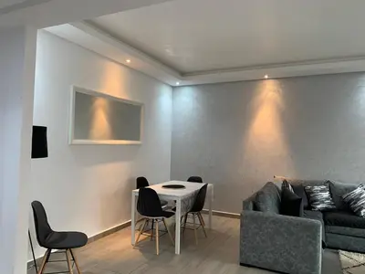 a living room with a couch and a table and chairs at Appartement de standing vue sur mer à Mohammedia in Mohammedia