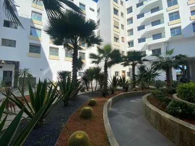 a courtyard with palm trees in front of a building at CORNICHE CASABLANCA - VINTAGE F2 NEUF in Casablanca