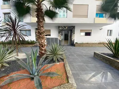a courtyard with palm trees in front of a building at CORNICHE CASABLANCA - VINTAGE F2 NEUF in Casablanca