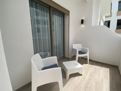 a room with two white chairs and a table at CORNICHE CASABLANCA - VINTAGE F2 NEUF in Casablanca