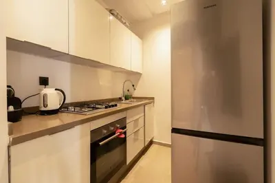 a kitchen with white cabinets and a stainless steel refrigerator at Metropolitan 06-Two Bedrooms - Cavalli Luxury Flat in Casablanca