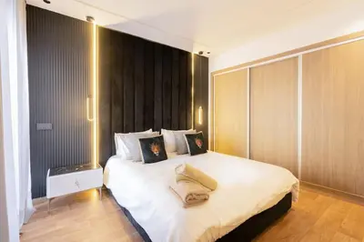 a bedroom with a large white bed with wooden walls at Metropolitan 06-Two Bedrooms - Cavalli Luxury Flat in Casablanca