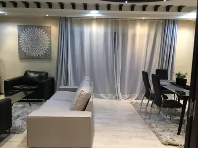 a living room with a couch and a table with chairs at Nice Apartment For Families- Bd Ghandi- Casablanca in Casablanca