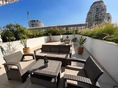 a patio with tables and chairs on a balcony at Duplex Rooftop d'exception terrasse panoramique de 100 m2 in Casablanca