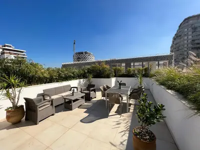 a rooftop patio with tables and chairs and plants at Duplex Rooftop d'exception terrasse panoramique de 100 m2 in Casablanca